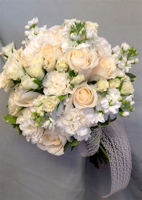 this bridal bouquet was done in white stock ivory spray roses white carnations and vendela