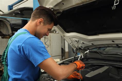 Professional Mechanic Fixing Modern Car At Automobile Repair Shop Stock