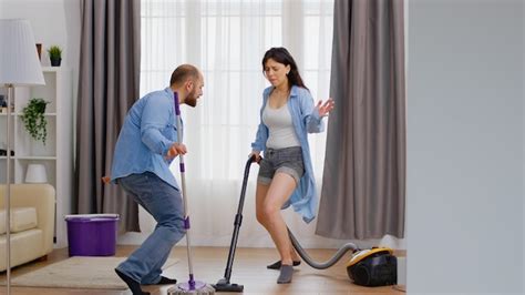 Premium Photo Happy Dancing Man And Woman Using Vacuum And Mop While Cleaning The House