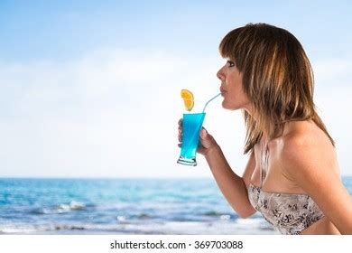 Woman Bikini Drinking Cocktail On Unfocused Stock Photo
