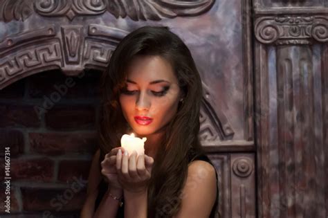 Portrait Of Beautiful Brunette Girl With Glowing Candle In Hands On