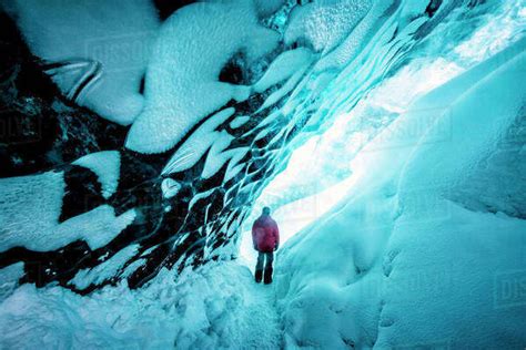 Hiker Walking In Ice Cave Stock Photo Dissolve