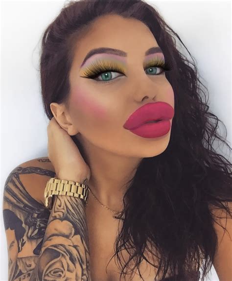 A Woman With Tattoos And Pink Lipstick On Her Face