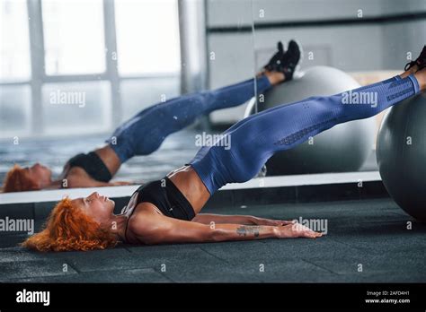 Using Silver Colored Exercise Ball Sporty Redhead Girl Have Fitness Day In Gym At Daytime