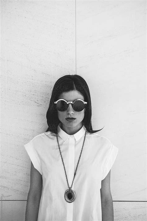 portrait of stilish fashion woman wearing round sunglasses and black necklace by stocksy