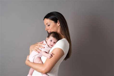 Una Joven Madre Con Su Bebé En Brazos Foto Premium