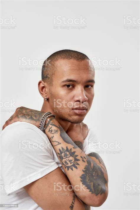Portrait Of Serious Young Mixed Race Tattooed Guy In White T Shirt