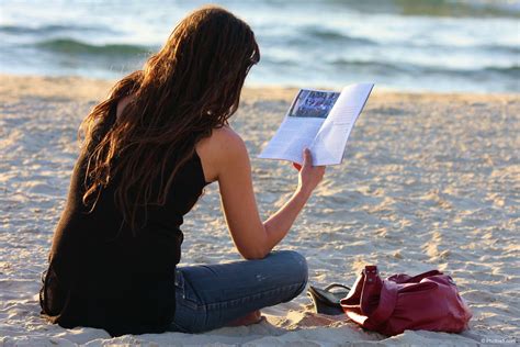 Woman Reading Book In Her Hand And Sitting On The Beach Photos Portfolio