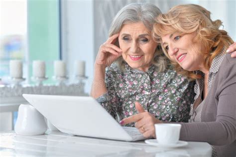 Two Senior Women Using Laptop Stock Photo Image Of Table Indoors