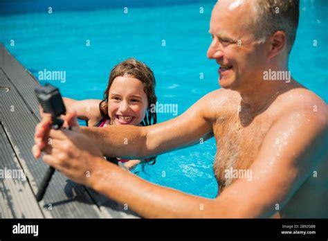 Happy Father And Daughter Having Fun In Swimming Pool Taking Photos And Videos With Waterproof