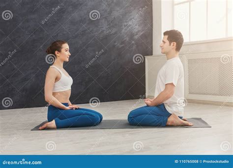 Young Couple Meditating Together Opposite Each Other Stock Photo