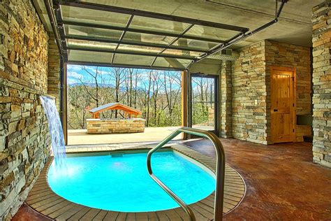 An Indoor Swimming Pool With A Hot Tub In The Middle And Stone Walls