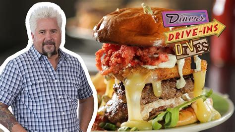 guy fieri eats a burger topped with hot cheese snacks diners drive ins and dives food