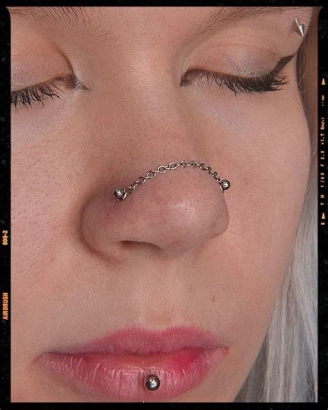 a close up of a woman s nose with a chain around her nose ring