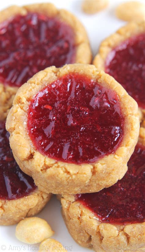 After the cookies are baked, press a miniature chocolate candy cup (my favorite is peanut butter) into the center and let cool completely. Peanut Butter & Jam Thumbprint Cookies | Amy's Healthy Baking