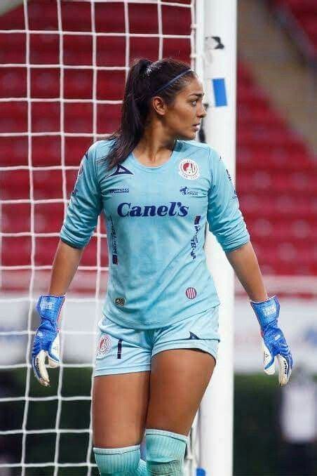 A Female Soccer Player Is Standing In Front Of The Goal