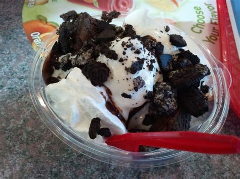 An Ice Cream Sundae With Oreo Cookies And Whipped Cream In A Plastic