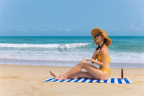 戴草帽比基尼美女沙滩上涂抹防晒高清图片下载 正版图片501754557 摄图网