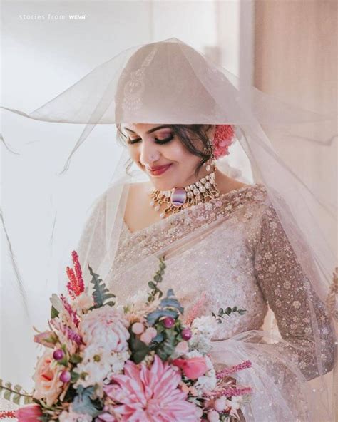 A Woman Wearing A Veil And Holding A Bouquet
