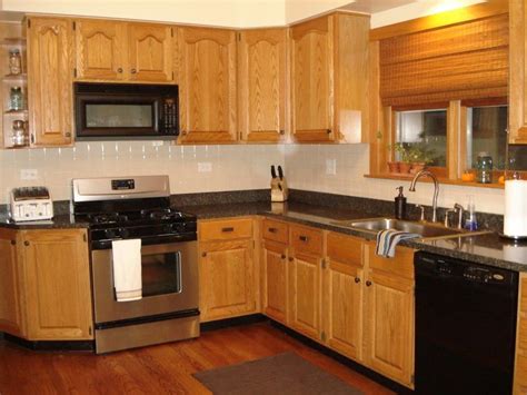 An amazing set of kitchen furniture crafted from solid oak wood. Kitchen. brown oak kitchen cabinet connected by black ...