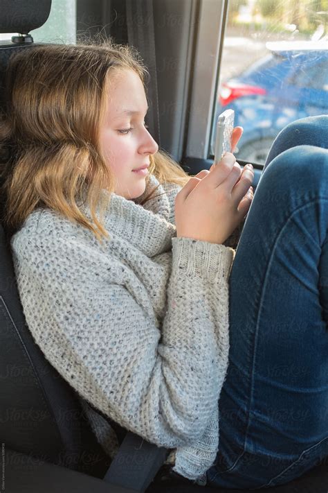 Teen Girl Waiting In The Car On Her Phone Del Colaborador De Stocksy