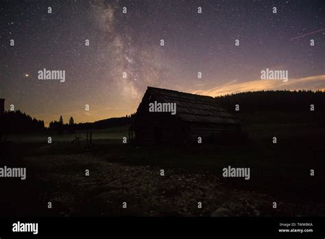 Purple Night Sky Stars Over Mountain And Old Wooden House Milky Way