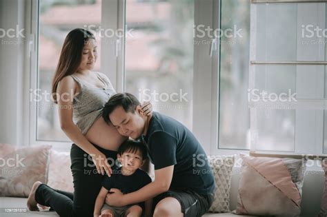 Asian Chinese Man Listening And Leaning On His Wifes Abdomen With His