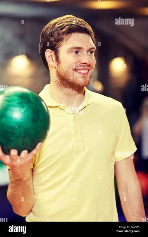 Happy Young Man Holding Ball In Bowling Club Stock Photo Alamy