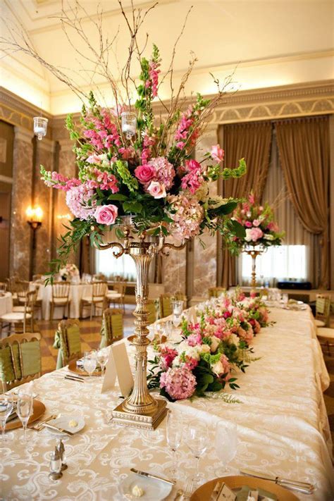 When we are planning wedding reception flowers for a client, we will consider the following types of arrangement: Love the hanging votives. Candelabra centerpiece i ...
