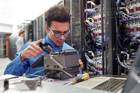 Male It Technician Fixing Equipment In Server Room Stock Photo Dissolve
