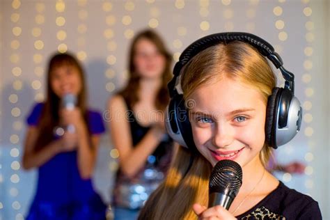 Groupe De Filles Heureuses Chantant Sur Le Karaoke Image Stock Image