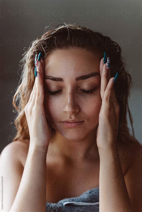 A Young Woman Rubbing Lotion On Her Body After Getting Out Of The Shower By Stocksy