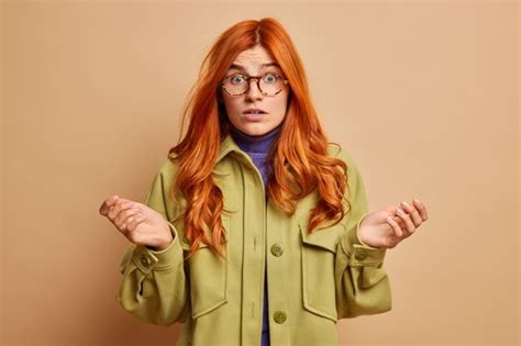Free Photo Indecisive Confused Redhead Woman Spreads Palms Sideways