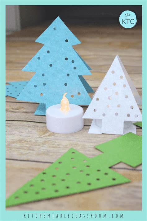 Paper Christmas Trees And A Candle On A Wooden Table