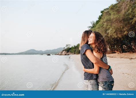 Two Smiling Friends Hugging Each Other On The Beach Stock Photo Image