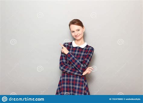 Portrait Of Cheerful Young Woman Pointing With Finger At Copy Space