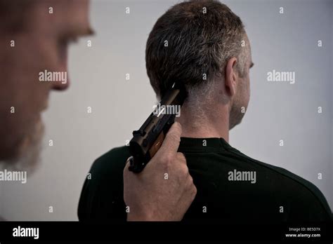 Man Holding Another Man A Gun To The Back Of His Head Stock Photo Alamy