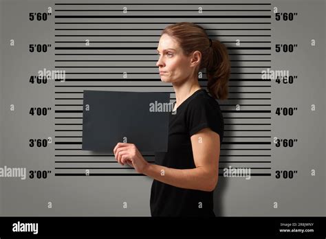 Criminal mugshot. Arrested woman with blank card against height chart