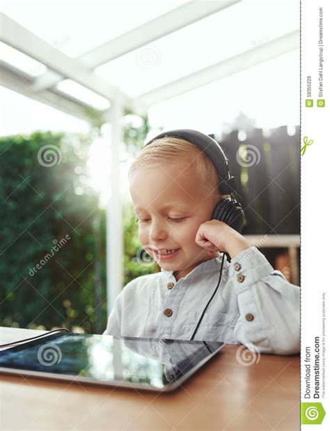 Little Boy Smiling In Delight Listening To Music Stock Photo Image Of