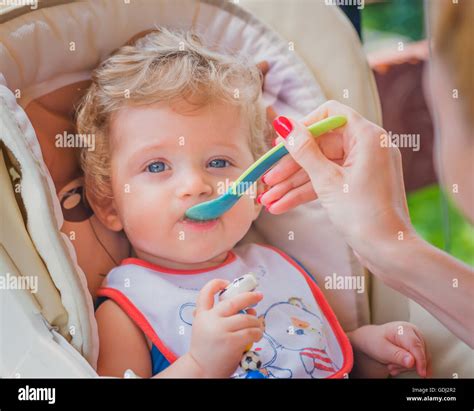 A Mother Feeding Her Baby Boy With Spoon Outdoor Stock Photo Alamy