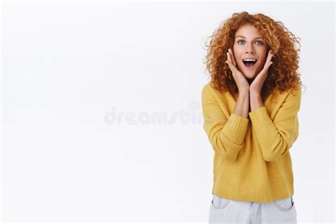 excited amused good looking caucasian redhead woman with curly hair look wondered and