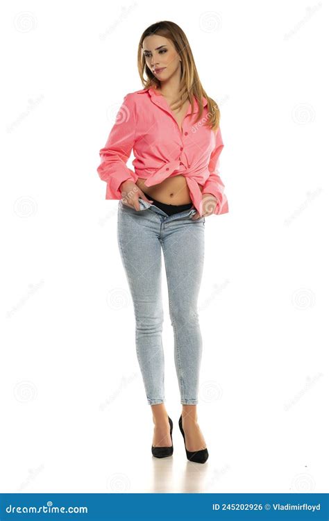 Charming Young Woman Posing In Studio In Pink Shirt And Unbuttoned Blue