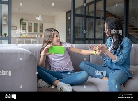 Dark Haired Mom Trying To Attract Attention Of Her Daughter Stock Photo