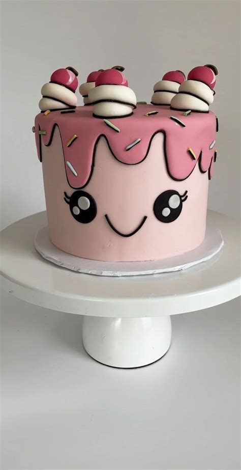 A Pink Cake With White Frosting And Sprinkles On Top Is Sitting On A Pedestal