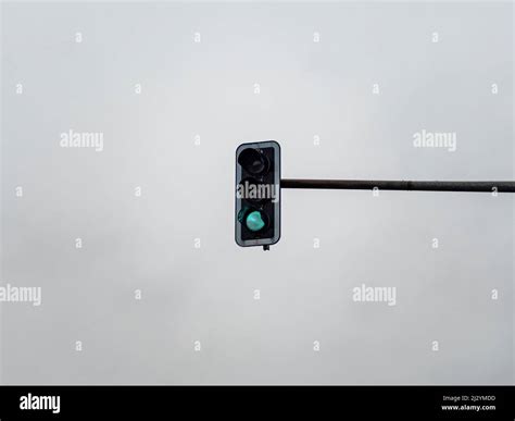Green Traffic Light Signal In Front Of An Overcast Sky Light Symbol To