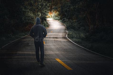 A Man Walking Alone On A Country Road Stock Photo Image Of Light