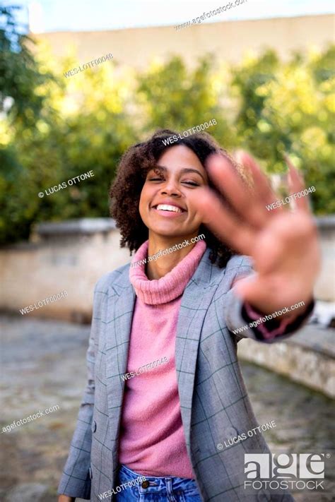 Portrait Of Laughing Young Woman Raising Hand Stock Photo Picture And