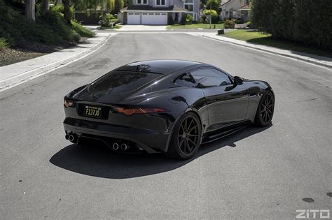 A Black Sports Car Is Parked On The Side Of The Road In Front Of A House