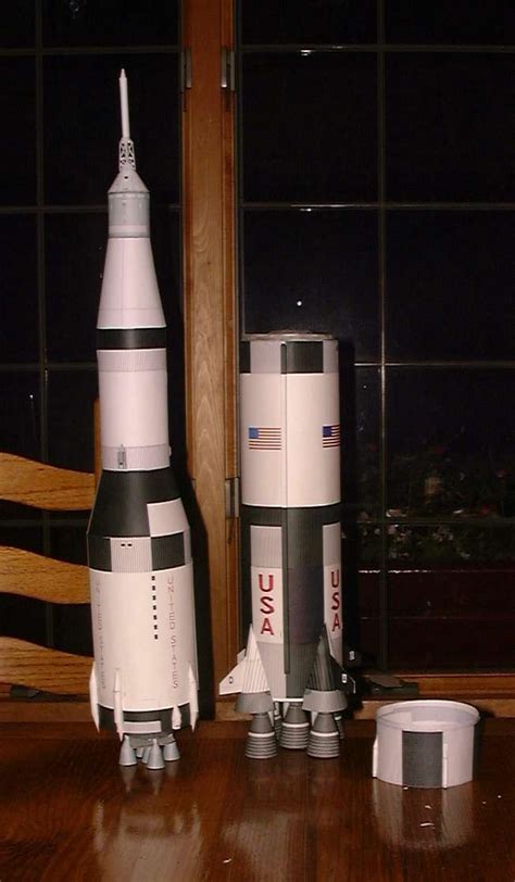 Two Model Rockets Sitting On Top Of A Wooden Table