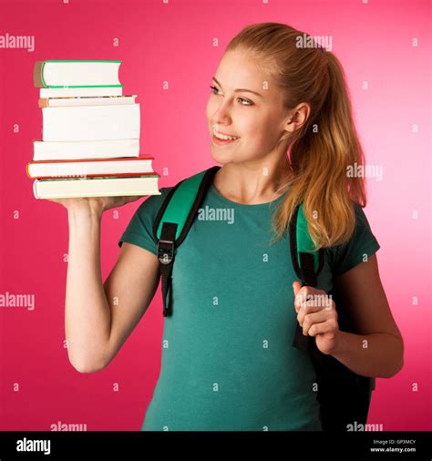 Blonde Student With Stack Of Books In Chest And Backpack Gesturing Ok